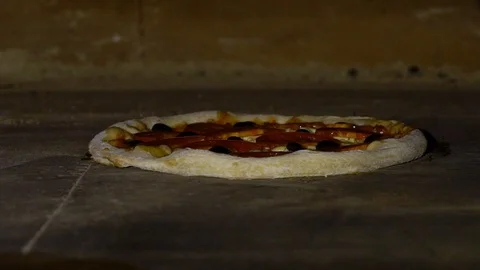 Moving pizza with shovel inside big restaurant oven in slow motion Stock Footage 101075266
