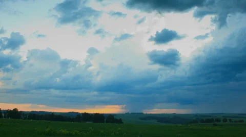 Moving rain clouds over field an sunset, time lapse. Stock Footage 43098622