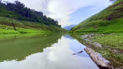 Moving reflection on rippling water surface flanked by green mountains Stock Footage 341755902
