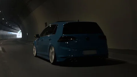 Moving rolling shot of a custom VW Volkswagen Golf car driving in a tunnel Stock Footage 127375824
