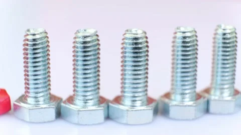 Moving row of galvanized metallic screws close-up, one of them is pink colored. Stock Footage 141332467