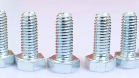Moving row of galvanized metallic screws close-up. Stock Footage 141384443