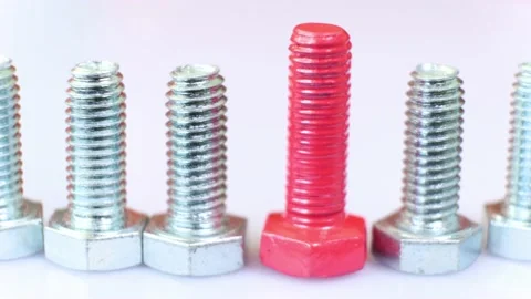 Moving row of galvanized metallic screws close-up, one of them is pink colored. Stock Footage 141916055