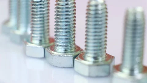 Moving row of galvanized metallic screws close-up. Stock Footage 141916634