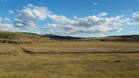 Moving rural scenery as seen through the vehicle window on the road, alongside a Stock Footage 140093241