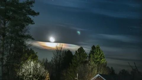 Moving scenic view on Moon rising behind fast moving thick colored cloud Stock Footage 143201039