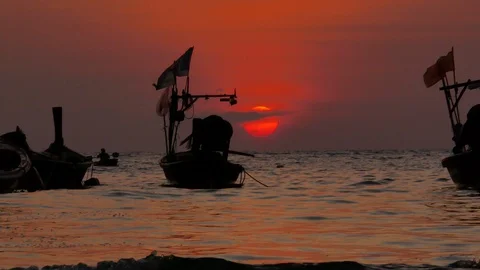 Moving sea wave, moving flag, long tail boat parking, orange sunset with clou Stock Footage 127924052