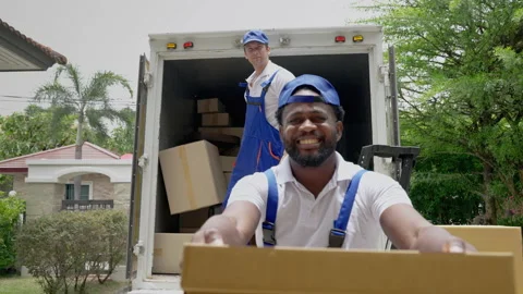Moving service workers outdoors, unloading boxes and checking list Stock Footage 205074788