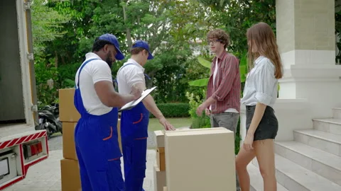 Moving service workers outdoors, unloading boxes and checking list Stock Footage 205074859