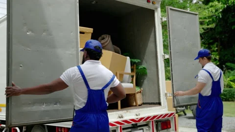 Moving service workers outdoors, unloading boxes and checking list Stock Footage 205223555