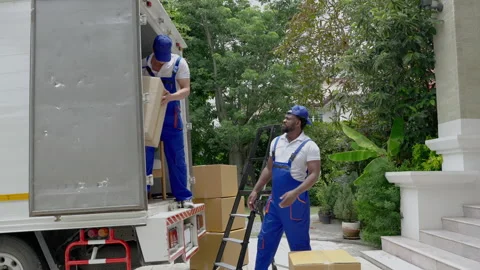 Moving service workers outdoors, unloading boxes and checking list Stock Footage 206833478