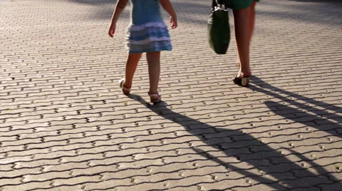 Moving shadows of walking mother and her child legs. Видео 44774740