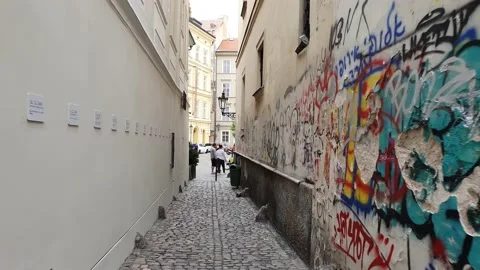 A moving shot along a street in old town. Street view with people and traffic. Video stock 166404470