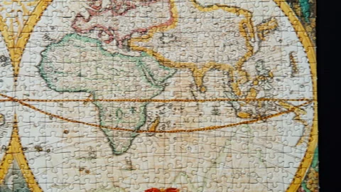 Moving shot completed jigsaw featuring world map. Puzzle pieces fit tightly Stock Footage 332310070