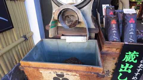 Moving shot of green tea roasting machine outside a store in Kyoto Stock Footage 265121165