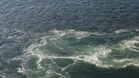 Moving shot of a powerful sea wake with swirling currents and white foam created Stock Footage 343321735