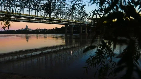 Moving shot of river, bridge w reflection, branches w leaves, evening 스톡 동영상 97537183