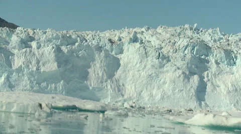 Moving shot sailing amongst small icebergs and glacier wall Stock Footage 60006014