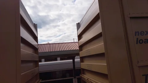 Moving sideways along moving train and lifting up to look along it as it Stock Footage 118508520