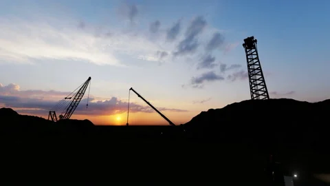 Moving silhouettes of cranes on a construction site, sunset time Stock Footage 149568670
