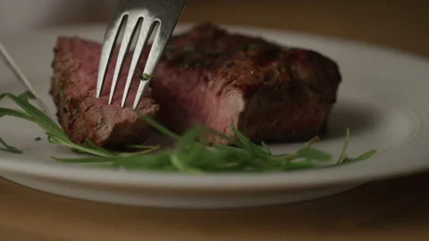 Moving a Slice of Steak on a Garnished Plate Stock Footage 208794937