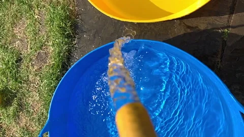 Moving slow motion water going from a blue to a yellow bucket. 스톡 동영상 130894793