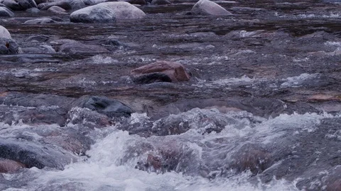 Moving slowly over foaming river water with stones in cloudy weather Video stock 108919151