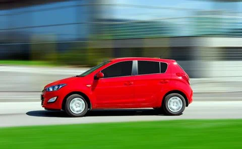 Moving small red car Stock Photos