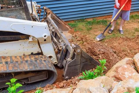 By moving soil with precision mini bulldozer is instrumental in transforming Stock Photos