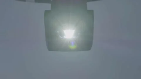 Moving Spotlight Lamp Shining Brightly in Indoor Setting With Neutral Background Stock Footage 334053257