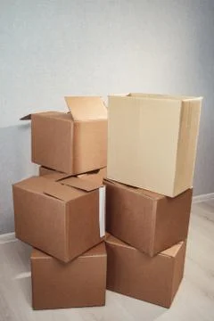 Moving in. Stack of cardboard boxes in the empty room Stockfoto's