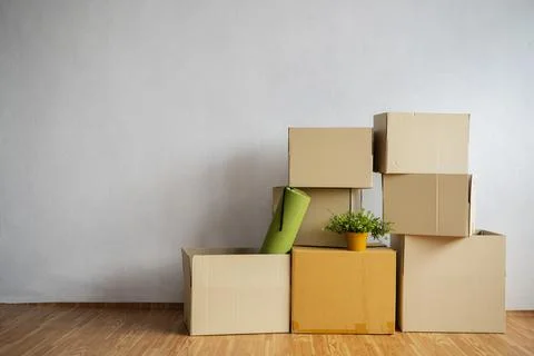 Moving in. Stack of cardboard boxes in the empty room Stock Photos