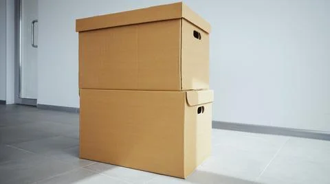 Moving in. Stack of two cardboard boxes in the empty room with copy space. A Stock Photos