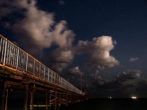 Moving stars and clouds above pier. 4K time-lapse video Stock Footage 80306427