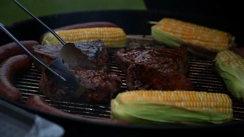 Moving steaks on a barbecue grill Video stock 132618477