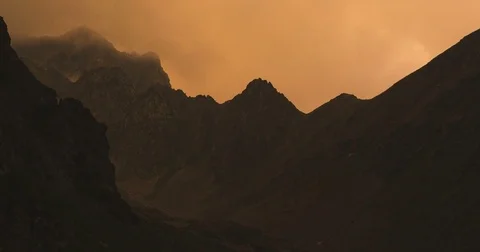 Moving storm clouds over the mountain tops at sunset Stock Footage 84742112