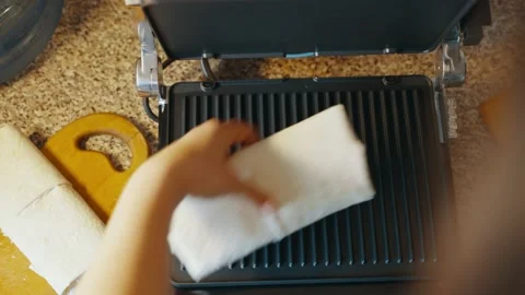 Moving the stuffed pita bread to the electric grill for further cooking Stock Footage 238701854