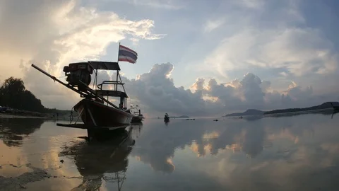 Moving thai flag on long tail fishing boat mooing on low tide water, flowing  Stock Footage 128309323