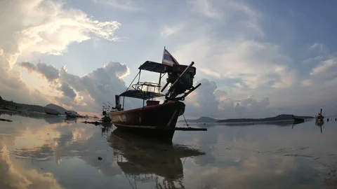 Moving thai flag on long tail fishing boat mooing on low tide water, flowing  Stock Footage 128342868