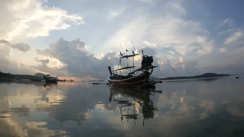 Moving thai flag on long tail fishing boat mooing on low tide water, flowing  Stock Footage 128347974