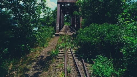 Moving through an overgrown rusty train bridge over the Merrimack River in Vídeo Stock 120828599
