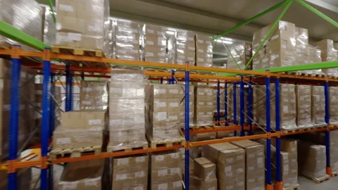 Moving through rows of steel racks filled with packages of cartons Видео 290589310