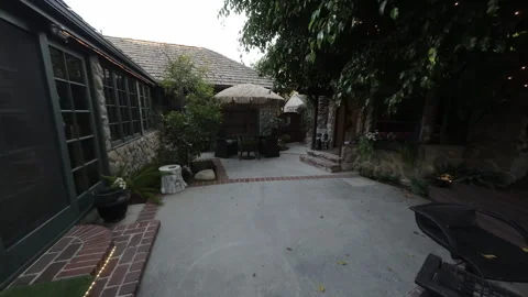 Moving through a stone cottage courtyard with French doors Stock Footage 345544487