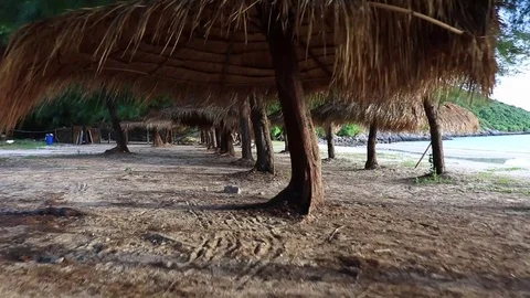 Moving Through Straw Umbrellas on the Tropical Beach Stockbeeldmateriaal 72140684