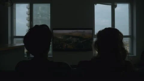 Moving towards camera shot of couple sitting on the couch and watching tv series Stock Footage 168235417