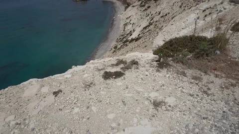 Moving towards the cliff edge and looking over wonderful transparent sea far Stockbeeldmateriaal 76989139