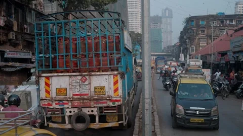 A moving traffic on a busy road passing through wholesale market in Mumbai Stock Footage 328501546