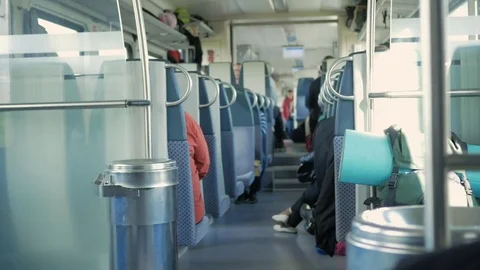 Moving train inside. People sit in their places, things are spread out on the Stock Footage 76314463