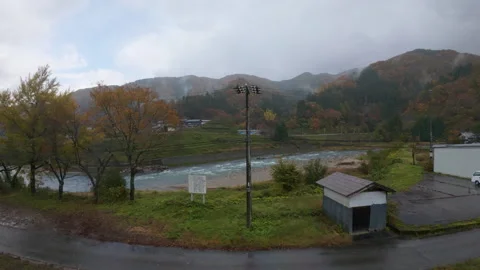 A moving train of a river flowing through a forest in the Japanese alps 库存影片 329619179