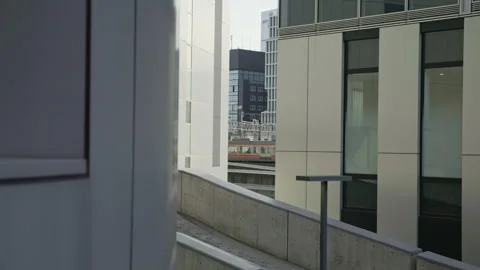 Moving train seen in a gap between buildings. Modern architecture. Stock Footage 217827963